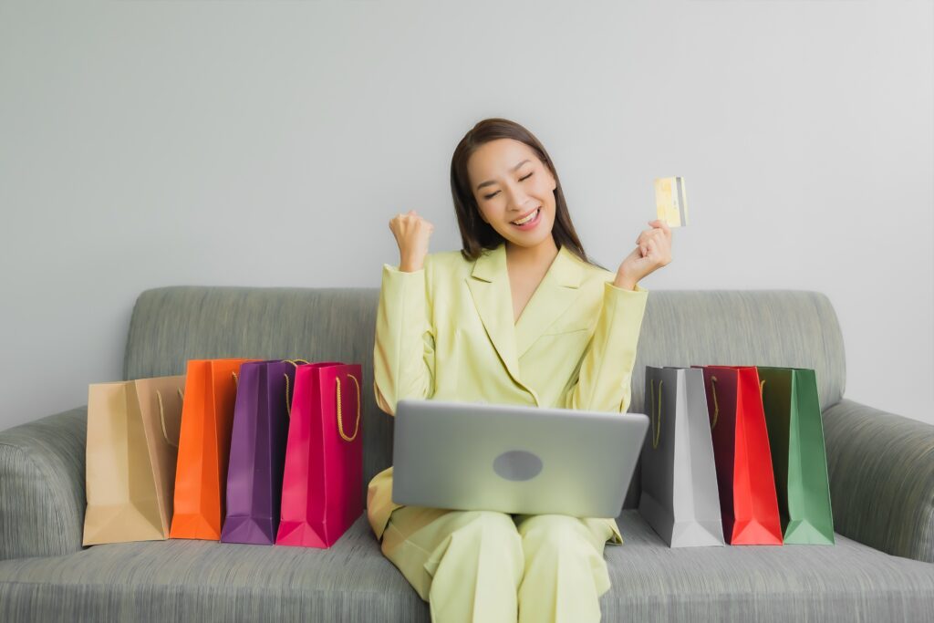 consumer behavior in online shopping, woman sitting on sofa buying stuff